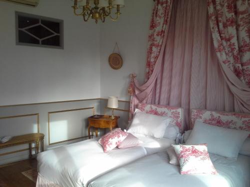 two beds in a room with pink curtains at La Thebaide in Saint-Trivier-de-Courtes