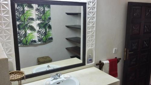 a bathroom with a sink and a large mirror at Villa Fortuna Malindi in Malindi