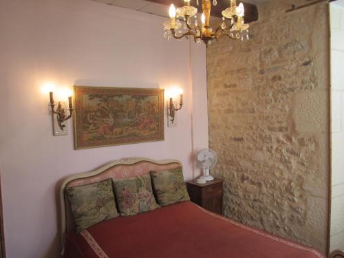 a bedroom with a bed and a wall with a painting at Rue des Douves in Verteuil-sur-Charente