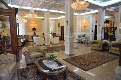 a lobby with chairs and a table in a building at Hotel Savona in Montecatini Terme