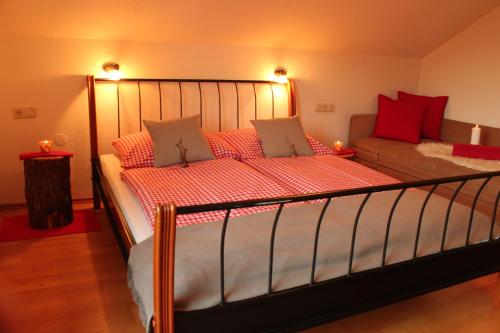 a bedroom with a bed with red pillows and a couch at Ferienhof Kreilgut in Rossleithen