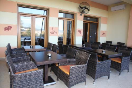 a dining room with tables and chairs and windows at Byzantio Hotel in Thessaloniki