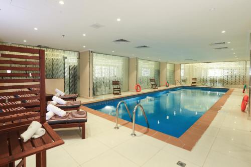 una piscina en una habitación de hotel con un banco en Prime Al Hamra Hotel en Yeda