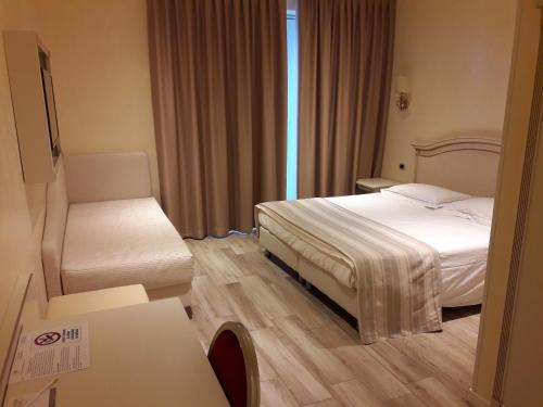 a hotel room with a bed and a chair at Palace Hotel & SPA La CONCHIGLIA D' ORO in Vicenza