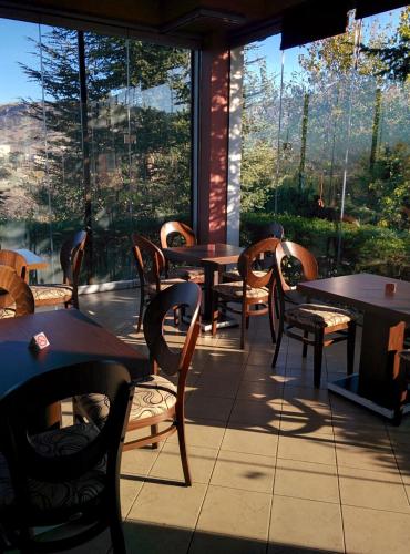 a restaurant with tables and chairs and a large window at Byzantio Hotel in Thessaloniki