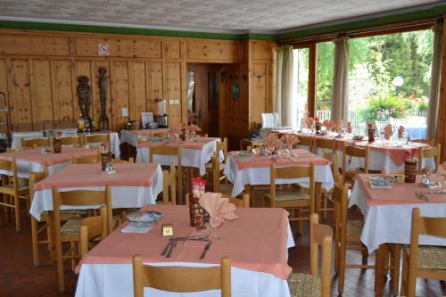 a dining room with tables and chairs with pink tablecloths at Albergo Cioccarelli in Aprica