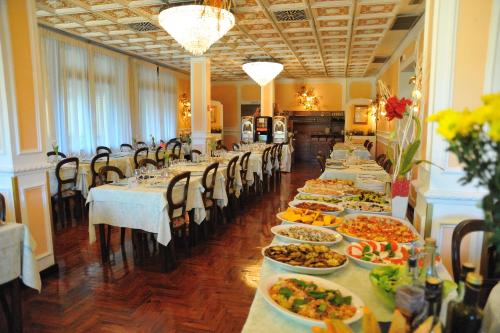 a row of tables with plates of food on them at Hotel Savona in Montecatini Terme