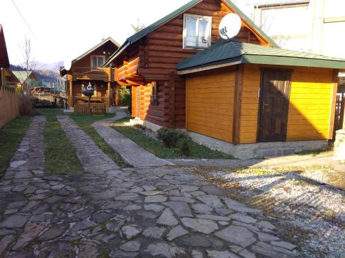 a cabin with a yellow door next to a stone driveway at Teremok in Tatariv