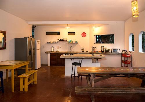 a kitchen that has a table and chairs in it at Hostel La Botella de Leche - Tamarindo in Tamarindo
