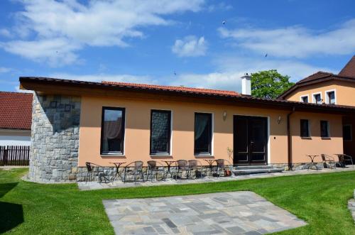 a house with tables and chairs in a yard at Penzion Marie - Žumberk in Žumberk