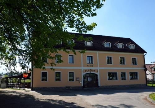 a large yellow building with a black roof at Penzion Marie - Žumberk in Žumberk