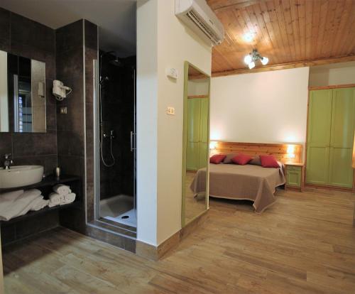 a bedroom with a bed and a shower and a sink at Club Hotel Lo Sciatore in San Massimo