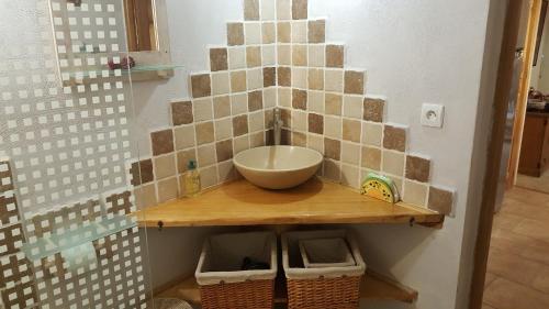 un bagno con lavandino su un bancone con cestini di L'Olivier Chez Mamé Marthe a Vallon-Pont-dʼArc