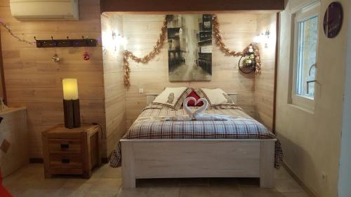una camera da letto con un letto in una stanza con pareti in legno di L'Olivier Chez Mamé Marthe a Vallon-Pont-dʼArc
