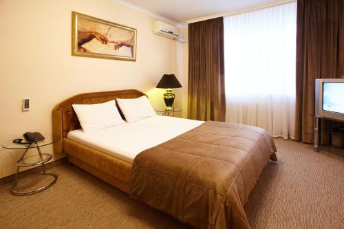 une chambre d'hôtel avec un lit et une télévision dans l'établissement Apartment Deluxe on Moscow Avenue, à Chişinău