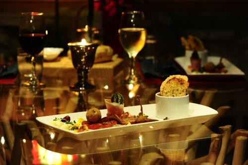 a plate of food on a table with wine glasses at El Refugio La Brisa del Diablo in Valle Hornito