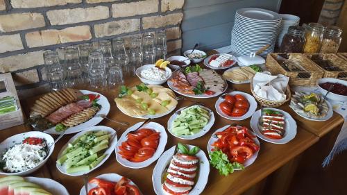 a table full of plates of food on a table at Folwark Hutta in Suwałki