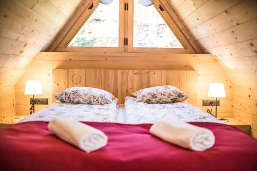 a bedroom with a bed with two pillows and a window at Osada domków TATRA-DREAM in Zakopane