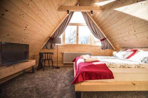 a bedroom with a bed and a large window at Osada domków TATRA-DREAM in Zakopane