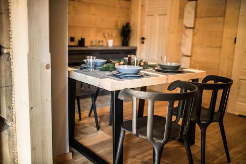 a table with chairs and bowls on it in a kitchen at Osada domków TATRA-DREAM in Zakopane