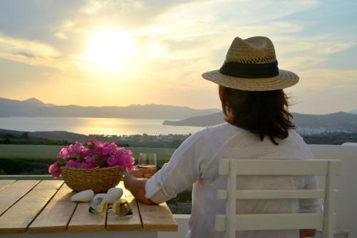 a woman sitting at a table looking at the sunset at Hawk Stone in Adamas