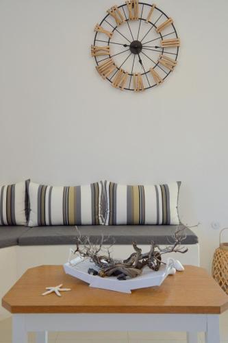 a table with a clock on the wall and a couch at Hawk Stone in Adamas
