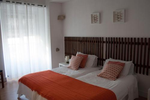 a bed room with a white bedspread and pillows at Avis Guesthouse in Évora
