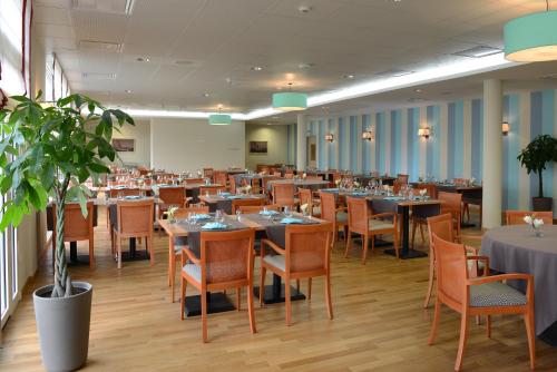 - une salle à manger avec des tables et des chaises dans l'établissement Domitys La Plage de Nacre, à Courseulles-sur-Mer