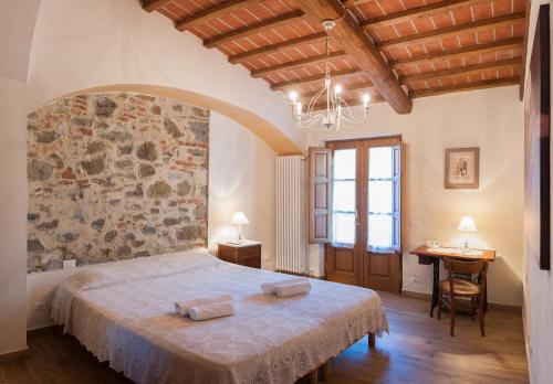 1 dormitorio con cama y pared de piedra en Casabeppe, en Lucca