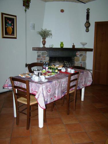 a dining room table with chairs and a fireplace at b&b da Maria in Fagagna