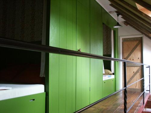 een groene muur in een kamer met een trap bij De Wilgenhof in Finsterwolde