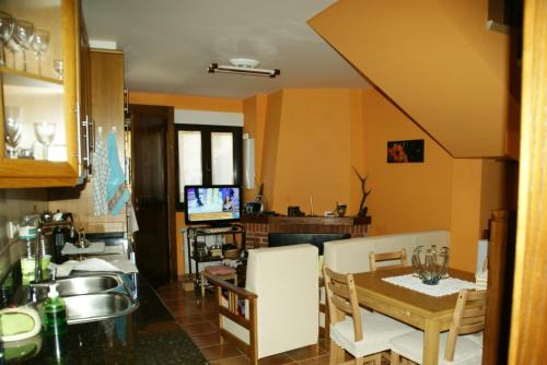 a kitchen with a table and a dining room at Casa rural Rosita in Santa Cruz de los Cuérragos