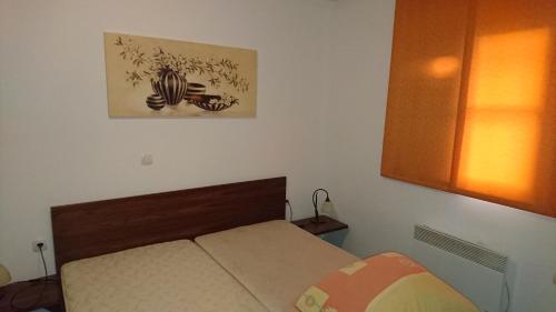 uma pequena cama num quarto com uma fotografia na parede em Apartma GEOTEH Terme Čatež 6032 em Krsko