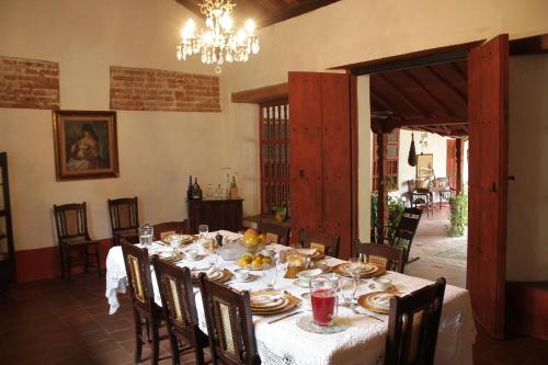 a dining room with a table with plates of food at CASA SINNING-año1637 in Mompos