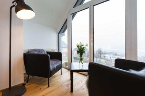 a living room with two chairs and a table with flowers at Appartement Auszeit in Sankt Michael im Lungau