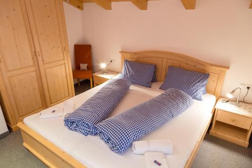 a bedroom with a bed with blue and white pillows at Ferienhaus Panorama in Biberwier