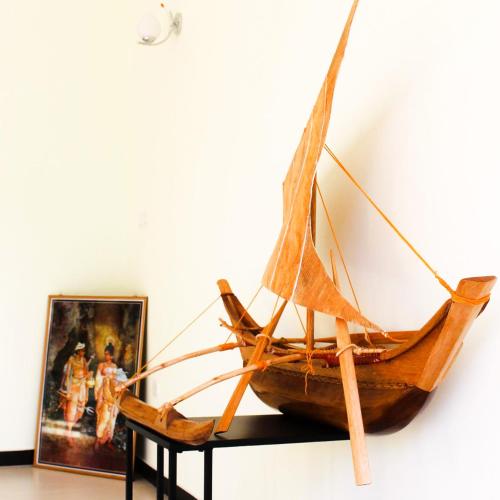 a wooden boat on a table next to a painting at The City Tourist Hotel in Anuradhapura