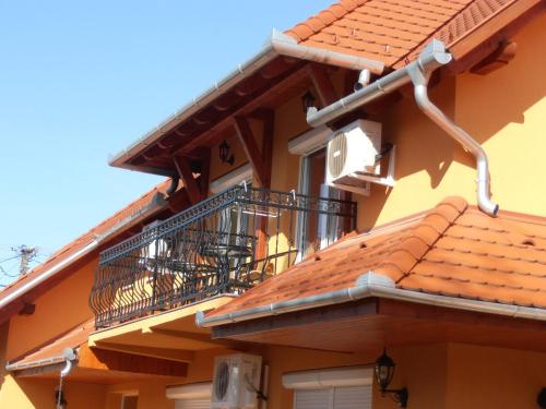 a yellow building with a balcony and a balcony at Gál Apartmanház in Harkány