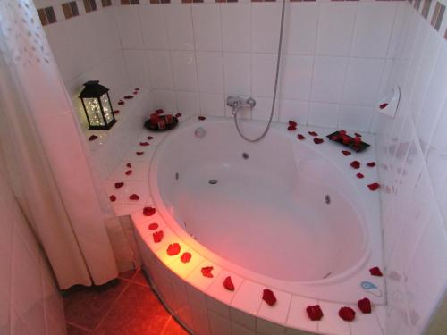 a bathroom with a tub with red flowers on the floor at Queen's Villa Hotel Boutique in Arequipa