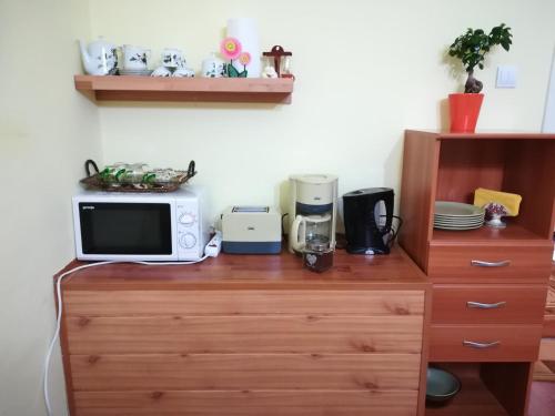 a microwave sitting on top of a wooden dresser at Casa Maria in Şura Mică