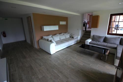 a living room with a white couch and two couches at Apartments Pri Jakobu in Kobarid