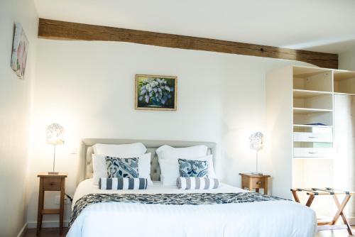 a bedroom with a large white bed with blue pillows at B&B Le Clos du Phare - En campagne in Saint-Samson-de-la-Roque