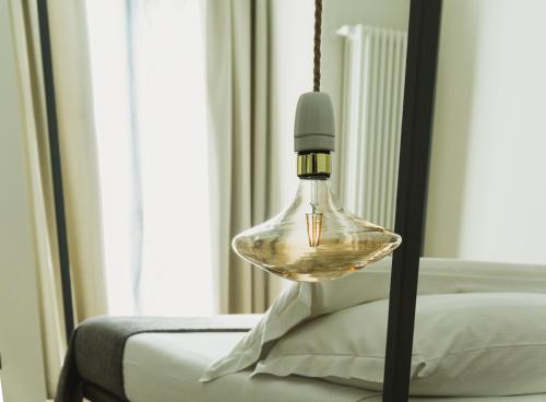 a glass light fixture hanging over a bed at Catania House in Catania