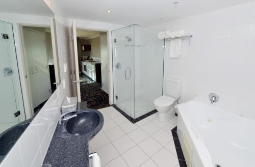 a bathroom with a shower and a toilet and a sink at Millennium Hotel New Plymouth, Waterfront in New Plymouth
