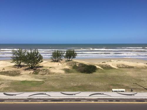 a view of a beach with the ocean in the background at Apartamento a beira mar in Capão da Canoa