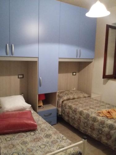 ブドーニにあるCasa Greyの青いキャビネット付きの部屋のベッド2台