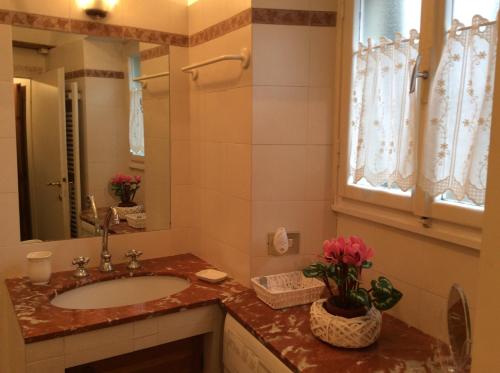 bagno con lavandino e specchio di Casa vacanze Amelia a Fiesole