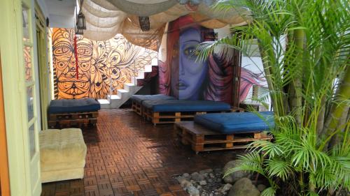 une pièce avec bancs et plantes dans un bâtiment dans l'établissement Oceanic Hostel, à Balneário Camboriú