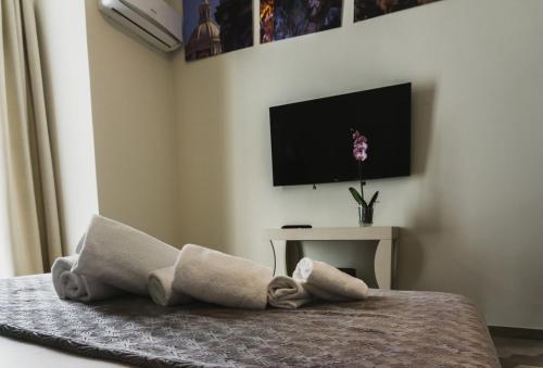 Schlafzimmer mit einem Bett und einem TV an der Wand in der Unterkunft Catania House in Catania