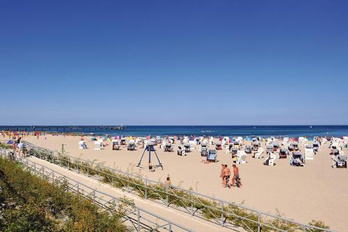 a beach with a lot of chairs and people on it at Morada Hotel Arendsee in Kühlungsborn